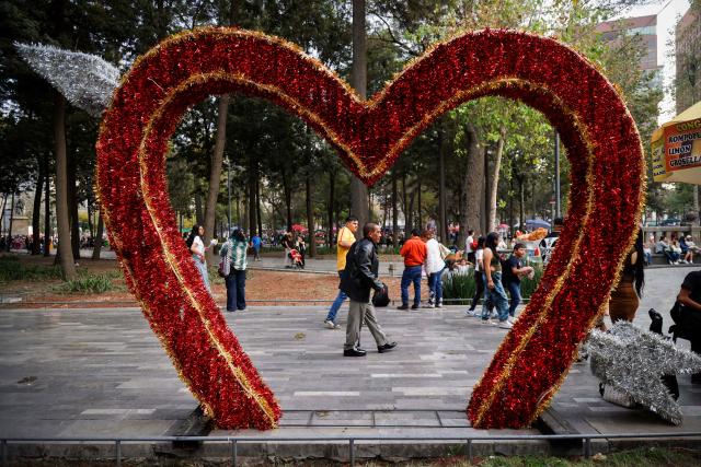 A man walks past an installation on Valentine's Day in Mexico City on February 14, 2026. (Photo by Rodrigo OROPEZA / AFP)