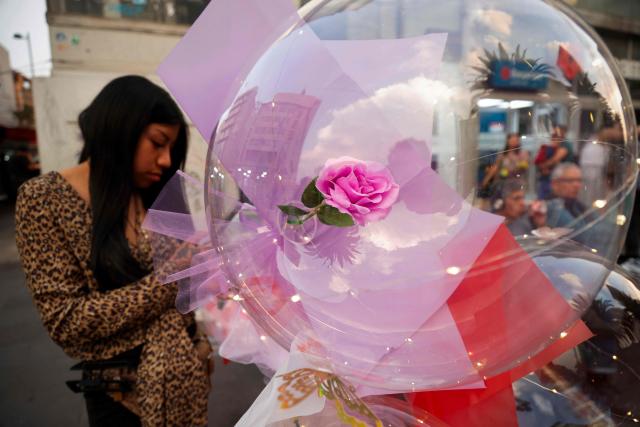 A young woman sells balloons on Valentine's Day in Mexico City on February 14, 2026. (Photo by Rodrigo OROPEZA / AFP)