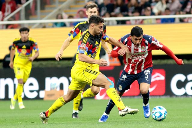 America's Uruguayan defender #04 Sebastian Caceres (L) and Guadalajara's defender #05 Bryan Gonzalez (R) fight for the ball during the Liga MX Clausura tournament football match between Guadalajara and America at the Akron Stadium in Zapopan, Jalico state, Mexico on February 14, 2026. (Photo by Ulises Ruiz / AFP)