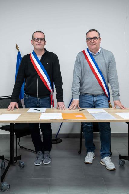 Mayors Arnaud Pageaud (R) and Jerome Squelard (L) pose with their mayor's sash at the city hall of Teillé, western France, on February 10, 2026. They share their office, their days, and above all their role: in the small commune of Teillé, in Loire-Atlantique department, western France, two mayors are in charge. Pleased with their arrangement, they are jointly seeking a new term in the municipal elections. (Photo by Sebastien Salom-Gomis / AFP)