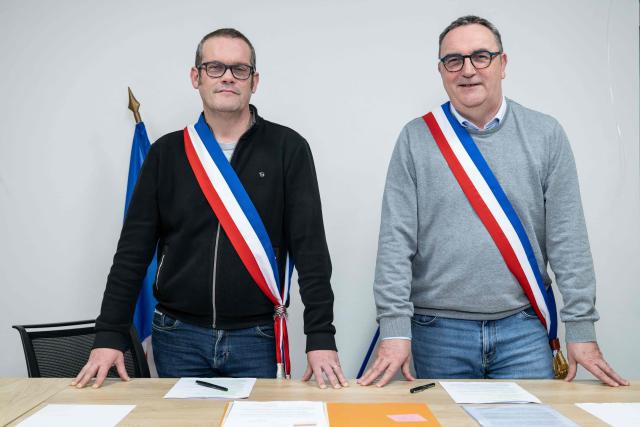 Mayors Arnaud Pageaud (R) and Jerome Squelard (L) pose with their mayor's sash at the city hall of Teillé, western France, on February 10, 2026. They share their office, their days, and above all their role: in the small commune of Teillé, in Loire-Atlantique department, western France, two mayors are in charge. Pleased with their arrangement, they are jointly seeking a new term in the municipal elections. (Photo by Sebastien Salom-Gomis / AFP)