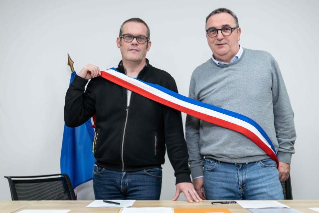 Mayors Arnaud Pageaud (R) and Jerome Squelard (L) pose with their mayor's sash at the city hall of Teillé, western France, on February 10, 2026. They share their office, their days, and above all their role: in the small commune of Teillé, in Loire-Atlantique department, western France, two mayors are in charge. Pleased with their arrangement, they are jointly seeking a new term in the municipal elections. (Photo by Sebastien Salom-Gomis / AFP)