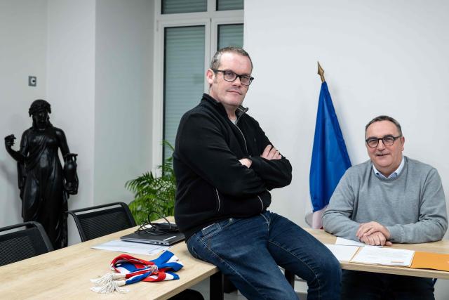 Mayors Arnaud Pageaud (R) and Jerome Squelard (L) pose at the city hall of Teillé, western France, on February 10, 2026. They share their office, their days, and above all their role: in the small commune of Teillé, in Loire-Atlantique department, western France, two mayors are in charge. Pleased with their arrangement, they are jointly seeking a new term in the municipal elections. (Photo by Sebastien Salom-Gomis / AFP)