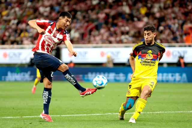 Guadalajara's US midfielder #23 Daniel Aguirre (L) kicks the ball past America's Uruguayan defender #04 Sebastian Caceres (R) during the Liga MX Clausura tournament football match between Guadalajara and America at the Akron Stadium in Zapopan, Jalico state, Mexico on February 14, 2026. (Photo by Ulises Ruiz / AFP)