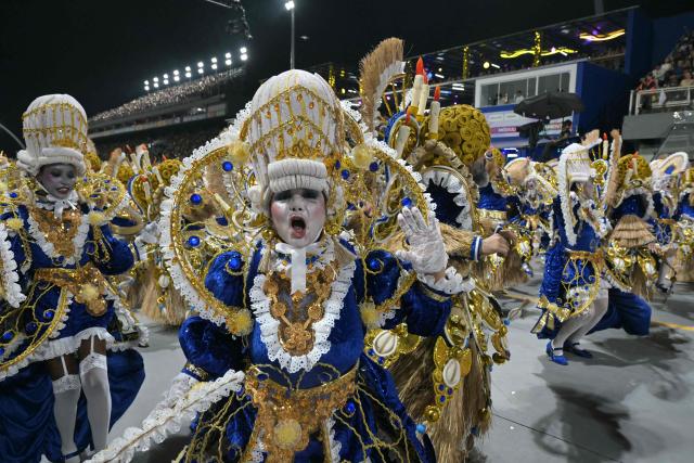 Revellers of the Mocidade Alegre samba school perform during the carnival parade at the Anhembi Sambadrome in Sao Paulo, Brazil, early on February 15, 2026. (Photo by Nelson ALMEIDA / AFP)