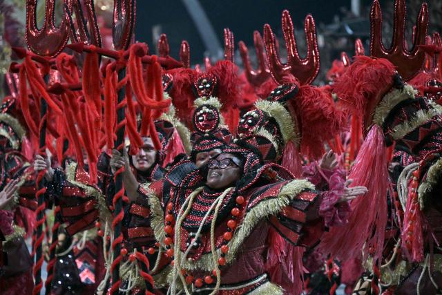 Revellers of the Mocidade Alegre samba school perform during the carnival parade at the Anhembi Sambadrome in Sao Paulo, Brazil, early on February 15, 2026. (Photo by Nelson ALMEIDA / AFP)