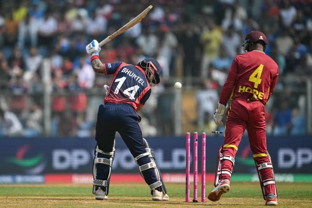 Nepal's Kushal Bhurtel (L) is clean bowled by West Indies' Akeal Hosein during the 2026 ICC Men's T20 Cricket World Cup group stage match between Nepal and West Indies at the Wankhede Stadium in Mumbai on February 15, 2026. (Photo by Indranil MUKHERJEE / AFP)