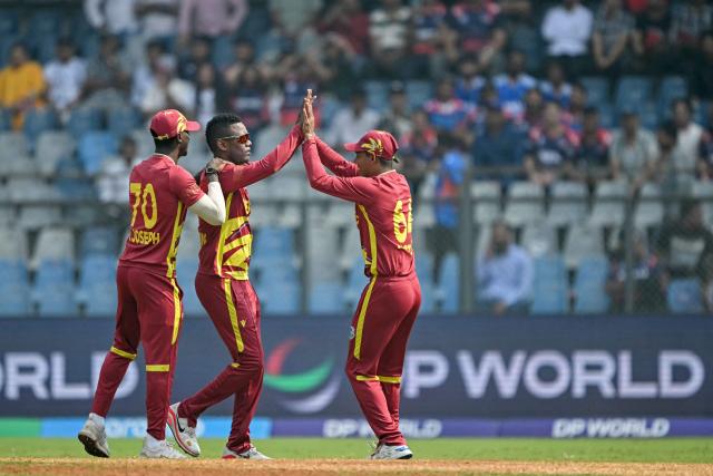 West Indies' Akeal Hosein (C) celebrates with teammates after taking the wicket of Nepal's Kushal Bhurtel during the 2026 ICC Men's T20 Cricket World Cup group stage match between Nepal and West Indies at the Wankhede Stadium in Mumbai on February 15, 2026. (Photo by Indranil MUKHERJEE / AFP)