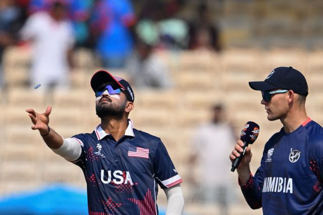 USA's captain Monank Patel (L) tosses the coin as his Namibian counterpart Gerhard Erasmus watches during the toss before the start of the 2026 ICC Men's T20 Cricket World Cup group stage match between USA and Namibia at the MA Chidambaram Stadium in Chennai on February 15, 2026. (Photo by R. Satish BABU / AFP)