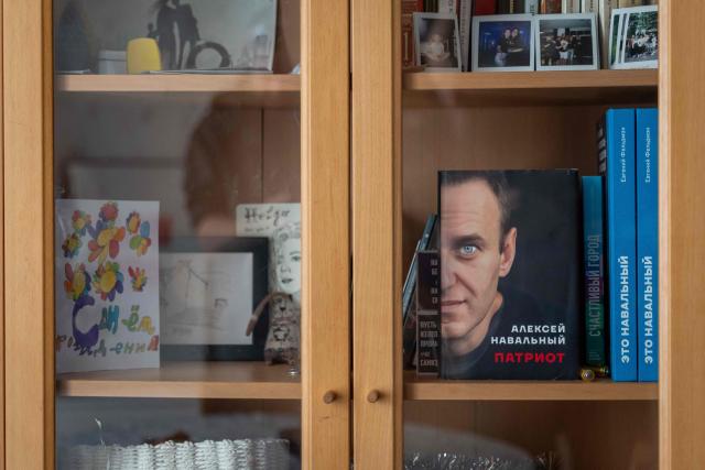 A copy of the autobiography of late Russian opposition leader Alexei Navalny entitled 'Patriot' is on display on a bookshelf in the apartment of Russian opposition activist Khelga Pirogova in Vilnius, Lithuania, on February 3, 2026. Russian opposition activist Khelga Pirogova defied the odds by winning election to a local council on behalf of late Kremlin foe Alexei Navalny's political movement in 2020. Forced to flee when Russia ramped up its persecution of opposition figures after invading Ukraine, she now faces her toughest battle yet: stage three cancer. The disease has left her exhausted, but no less committed to fighting Russian President Vladimir Putin's government -- even if she has to do both from outside her homeland. (Photo by Wojtek RADWANSKI / AFP)