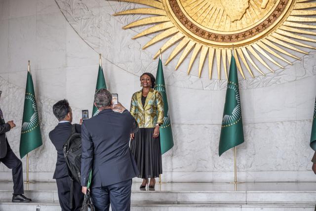 A delegate poses for a photograph in front of the entrance to the Nelson Mandela Hall during the 39th Ordinary Session of the Assembly of the African Union at the AU Headquarters in Addis Ababa on February 15, 2026. (Photo by Marco Simoncelli / AFP)