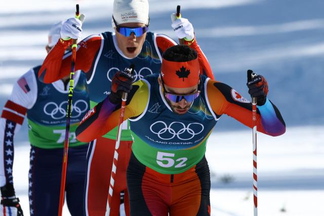 Canada's Antoine Cyr (R) and Norway's Martin Loewstroem Nyenget compete during the cross-country men's 4 x 7,5km relay event of the Milano Cortina 2026 Winter Olympic Games at Tesero Cross-Country Skiing Stadium in Lago di Tesero (Val di Fiemme), on February 15, 2026. (Photo by Anne-Christine POUJOULAT / AFP)