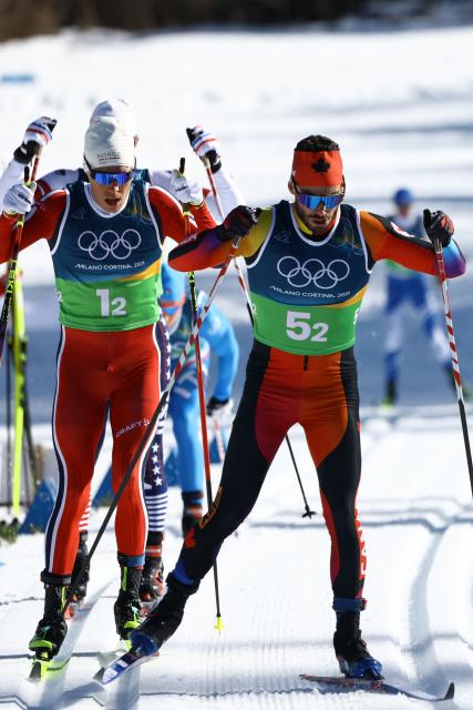 Canada's Antoine Cyr (R) and Norway's Martin Loewstroem Nyenget compete during the cross-country men's 4 x 7,5km relay event of the Milano Cortina 2026 Winter Olympic Games at Tesero Cross-Country Skiing Stadium in Lago di Tesero (Val di Fiemme), on February 15, 2026. (Photo by Anne-Christine POUJOULAT / AFP)
