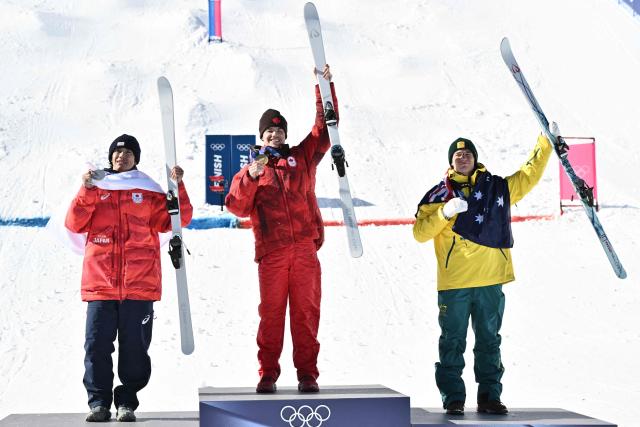 (From L) Silver medallist Japan's Ikuma Horishima, gold medallist Canada's Mikael Kingsbury, bronze medallist Australia's Matt Graham celebrate on the podium after the freestyle skiing men's dual moguls final during the Milano Cortina 2026 Winter Olympic Games at Livigno Aerials & Moguls Park, in Livigno (Valtellina), on February 15, 2026. (Photo by Jeff PACHOUD / AFP)
