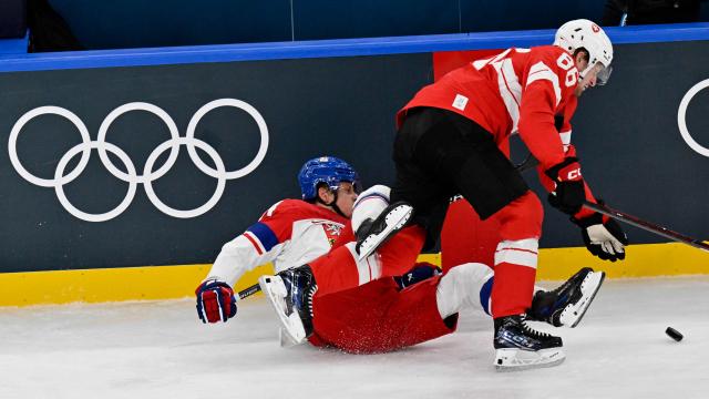 Czech Republic's #14 Filip Chlapik and Switzerland's #86 Janis Moser vie for the puck during men's preliminary round Group A Ice Hockey match between Switzerland and Czech Republic at the Milano Santagiulia Ice Hockey Arena during the Milano Cortina 2026 Winter Olympic Games in Milan, on February 15, 2026. (Photo by Alexander NEMENOV / AFP)