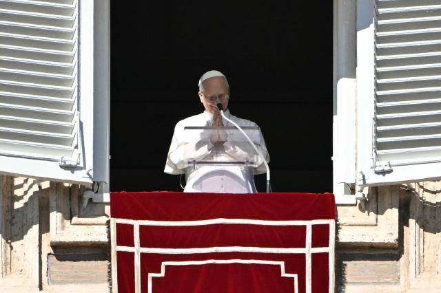 Pope Leo XIV greets the crowd from the window of the apostolic palace overlooking St. Peter's square during the Angelus prayer in the Vatican on February 15, 2026. (Photo by Andreas SOLARO / AFP)
