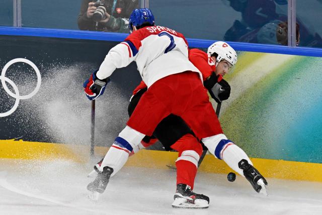 Czech Republic's #07 David Spacek and Switzerland's #13 Nico Hischier vie for the puck during men's preliminary round Group A Ice Hockey match between Switzerland and Czech Republic at the Milano Santagiulia Ice Hockey Arena during the Milano Cortina 2026 Winter Olympic Games in Milan, on February 15, 2026. (Photo by Alexander NEMENOV / AFP)