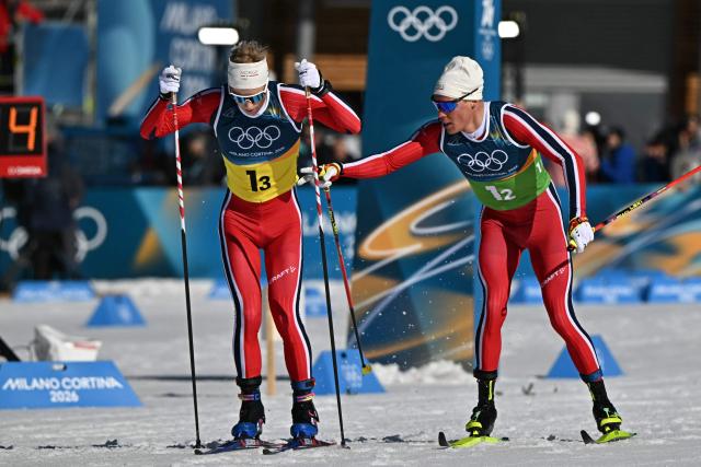 Norway's Martin Loewstroem Nyenget (R) hands the relay to Norway's Einar Hedegart during the cross-country men's 4 x 7,5km relay event of the Milano Cortina 2026 Winter Olympic Games at Tesero Cross-Country Skiing Stadium in Lago di Tesero (Val di Fiemme), on February 15, 2026. (Photo by Javier SORIANO / AFP)