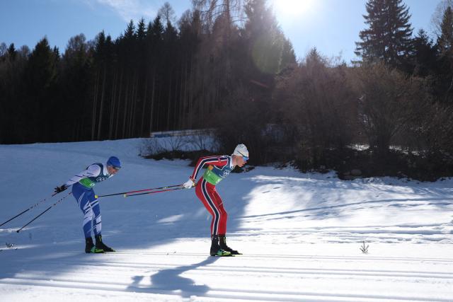 Finland's Iivo Niskanen (L) and Norway's Martin Loewstroem Nyenget compete during the cross-country men's 4 x 7,5km relay event of the Milano Cortina 2026 Winter Olympic Games at Tesero Cross-Country Skiing Stadium in Lago di Tesero (Val di Fiemme), on February 15, 2026. (Photo by Anne-Christine POUJOULAT / AFP)