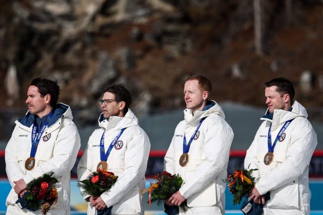 Bronze medallists Norway's Tarjei Boe, Johannes Thingnes Boe, Ole Einar Bjorndalen and Emil Hegle Svendsen pose on the podium of the medal reallocation ceremony of the Sochi 2014 biathlon men's 4x7.5km relay event during the Milano Cortina 2026 Winter Olympic Games at the Anterselva Biathlon Arena (Sudtirol Arena) in Anterselva (Val Pusteria) on February 15, 2026. (Photo by FRANCK FIFE / AFP)