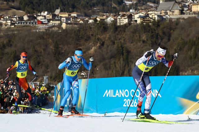 Canada's Remi Drolet (L), Italy's Martino Carollo and France's Mathis Desloges compete during the cross-country men's 4 x 7,5km relay event of the Milano Cortina 2026 Winter Olympic Games at Tesero Cross-Country Skiing Stadium in Lago di Tesero (Val di Fiemme), on February 15, 2026. (Photo by Anne-Christine POUJOULAT / AFP)
