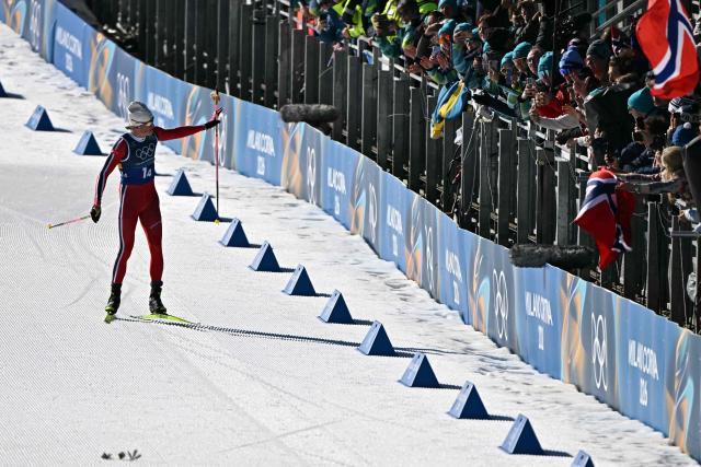 Norway's Johannes Hoesflot Klaebo (L) reacts as he skies to the finish line to win the cross-country men's 4 x 7,5km relay event of the Milano Cortina 2026 Winter Olympic Games at Tesero Cross-Country Skiing Stadium in Lago di Tesero (Val di Fiemme), on February 15, 2026. (Photo by Javier SORIANO / AFP)