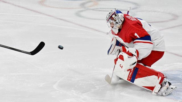 Czech Republic's #01 Lukas Dostal tries to save the puck during men's preliminary round Group A Ice Hockey match between Switzerland and Czech Republic at the Milano Santagiulia Ice Hockey Arena during the Milano Cortina 2026 Winter Olympic Games in Milan, on February 15, 2026. (Photo by Alexander NEMENOV / AFP)