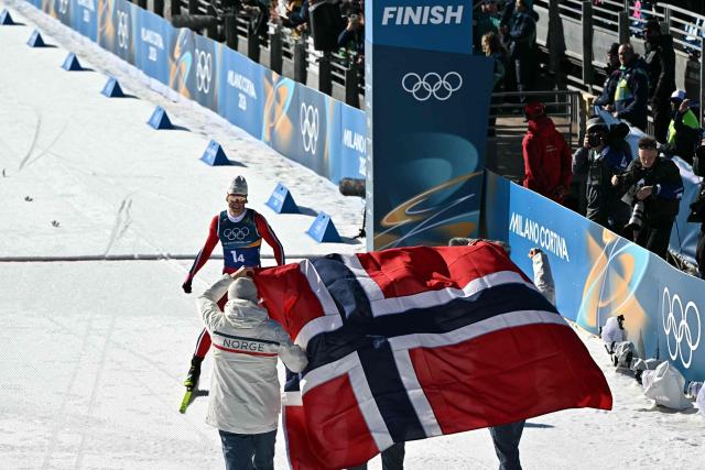 Norway's Johannes Hoesflot Klaebo (top C) celebrates after crossing the finish line to win the cross-country men's 4 x 7,5km relay event of the Milano Cortina 2026 Winter Olympic Games at Tesero Cross-Country Skiing Stadium in Lago di Tesero (Val di Fiemme), on February 15, 2026. (Photo by Javier SORIANO / AFP)