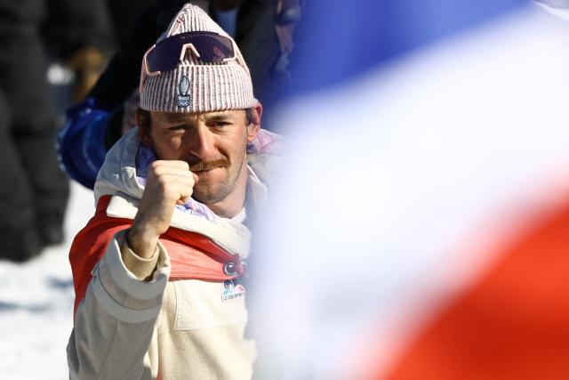 Silver medallist France's Hugo Lapalus celebrates after the cross-country men's 4 x 7,5km relay event of the Milano Cortina 2026 Winter Olympic Games at Tesero Cross-Country Skiing Stadium in Lago di Tesero (Val di Fiemme), on February 15, 2026. (Photo by Anne-Christine POUJOULAT / AFP)