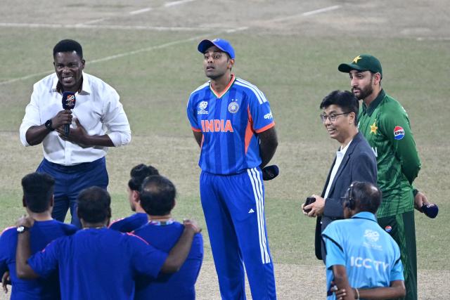 India's captain Suryakumar Yadav (C) looks on during the toss alongside his Pakistan counterpart Salman Agha (R) before the start of the 2026 ICC Men's T20 Cricket World Cup group stage match between India and Pakistan at the R Premadasa Stadium in Colombo on February 15, 2026. (Photo by Ishara S. KODIKARA / AFP)