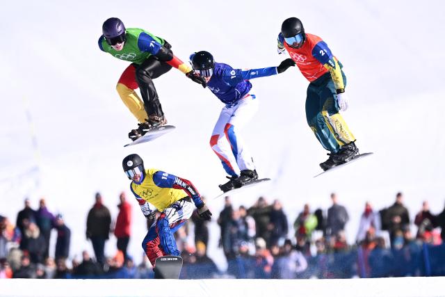 (L-R) Germany's Leon Ulbricht, Czech Republic's Radek Houser, France's Jonas Chollet and Australia's Adam Lambert compete in the snowboard mixed team cross quarter final 4 during the Milano Cortina 2026 Winter Olympic Games at Livigno Snow Park, in Livigno (Valtellina), on February 15, 2026. (Photo by Kirill KUDRYAVTSEV / AFP)