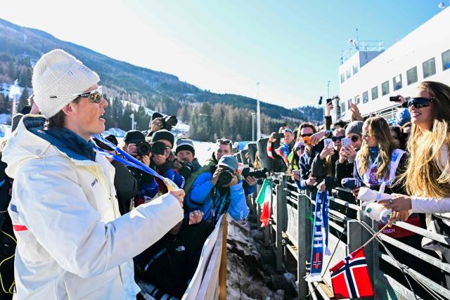 Gold medallist Norway's Johannes Hoesflot Klaebo (L) celebrates with his medal after the cross-country men's 4 x 7,5km relay event of the Milano Cortina 2026 Winter Olympic Games at Tesero Cross-Country Skiing Stadium in Lago di Tesero (Val di Fiemme), on February 15, 2026. (Photo by Tobias SCHWARZ / AFP)
