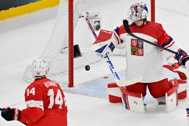 Switzerland's #14 Dean Kukan scores his team's fourth goal against Czech Republic's #01 Lukas Dostal during men's preliminary round Group A Ice Hockey match between Switzerland and Czech Republic at the Milano Santagiulia Ice Hockey Arena during the Milano Cortina 2026 Winter Olympic Games in Milan, on February 15, 2026. Switzerland won the match 4-3. (Photo by Alexander NEMENOV / AFP)