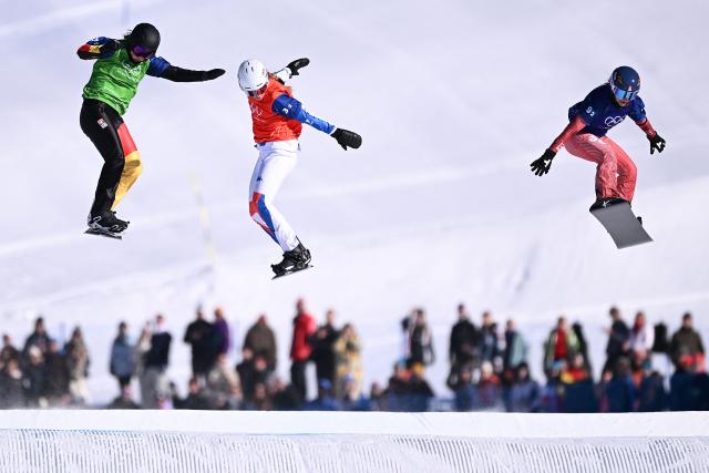 (L-R) Germany's Jana Fischer, France's Julia Nirani-Pereira and Switzerland's Noemie Wiedmer compete in the snowboard mixed team cross small final during the Milano Cortina 2026 Winter Olympic Games at Livigno Snow Park, in Livigno (Valtellina), on February 15, 2026. (Photo by Kirill KUDRYAVTSEV / AFP)