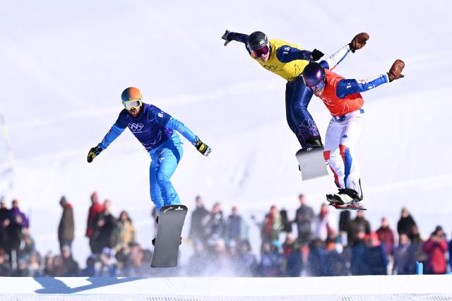 (L-R) Italy's Lorenzo Sommariva, Britain's Huw Nightingale and France's Loan Bozzolo compete in the snowboard mixed team cross final during the Milano Cortina 2026 Winter Olympic Games at Livigno Snow Park, in Livigno (Valtellina), on February 15, 2026. (Photo by Kirill KUDRYAVTSEV / AFP)
