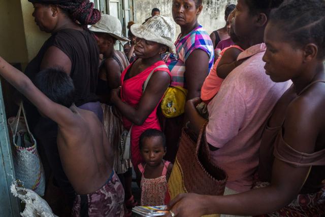 Residents queue during a food distribution at a public primary school used as a shelter for people affected by the passage of tropical cyclone Gezani during the night of February 10 to 11, in Toamasina on February 15, 2026. (Photo by RIJASOLO / AFP)