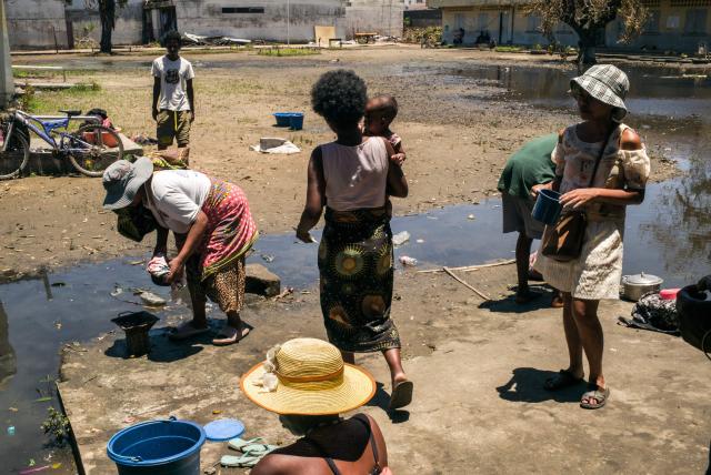 A woman carries a baby at a public primary school used as a shelter for people affected by the passage of tropical cyclone Gezani during the night of February 10 to 11, in Toamasina on February 15, 2026. (Photo by RIJASOLO / AFP)