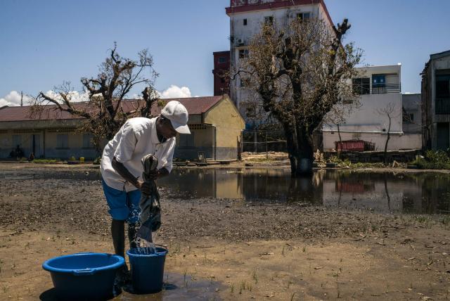 A resident washes his clothes at a public primary school used as a shelter for people affected by the passage of tropical cyclone Gezani during the night of February 10 to 11, in Toamasina on February 15, 2026. (Photo by RIJASOLO / AFP)