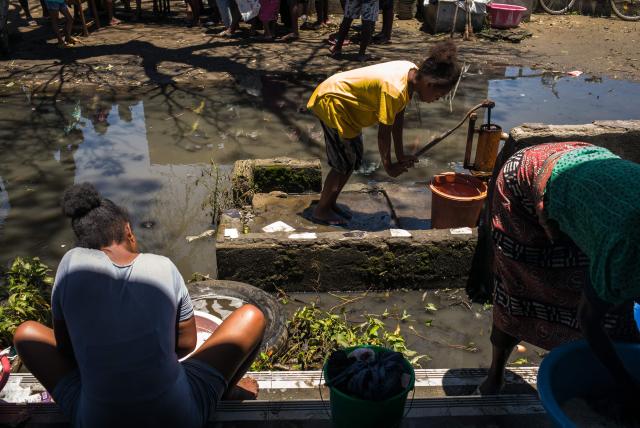 A resident fetches water at a public primary school used as a shelter for people affected by the passage of tropical cyclone Gezani during the night of February 10 to 11, in Toamasina on February 15, 2026. (Photo by RIJASOLO / AFP)