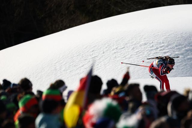 Spectators watch as Norway's Maren Kirkeeide skis during the women's biathlon 10km pursuit event during the Milano Cortina 2026 Winter Olympic Games at the Anterselva Biathlon Arena (Sudtirol Arena) in Anterselva (Val Pusteria) on February 15, 2026. (Photo by FRANCK FIFE / AFP)