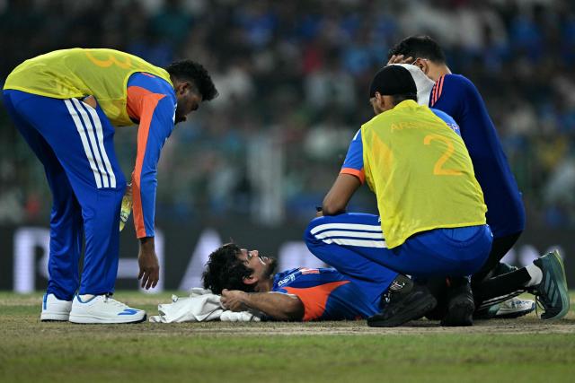 India's Ishan Kishan (2L) receives medical treatment during the 2026 ICC Men's T20 Cricket World Cup group stage match between India and Pakistan at the R Premadasa Stadium in Colombo on February 15, 2026. (Photo by Manan VATSYAYANA / AFP)
