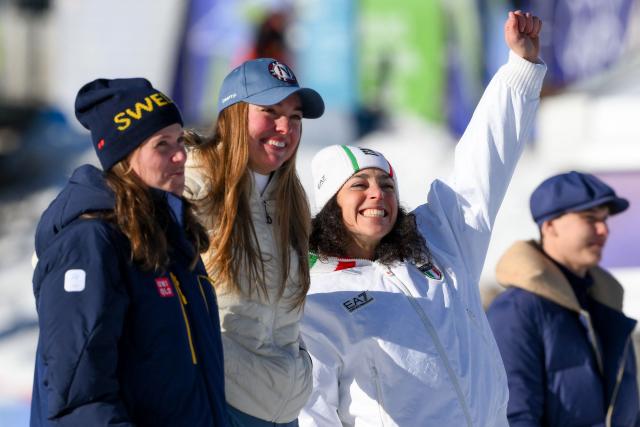 Gold medallist Italy's Federica Brignone (R) and tied silver medallists Norway's Thea Louise Stjernesund (C) and Sweden's Sara Hector (L) celebrate on the podium of the women's giant slalom event during the Milano Cortina 2026 Winter Olympic Games at the Tofane Alpine Skiing Centre in Cortina d’Ampezzo on February 15, 2026. (Photo by Marco BERTORELLO / AFP)