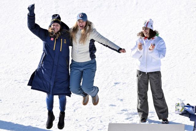 Gold medallist Italy's Federica Brignone (R) and tied silver medallists Norway's Thea Louise Stjernesund (C) and Sweden's Sara Hector (L) celebrate  on the podium of the women's giant slalom event during the Milano Cortina 2026 Winter Olympic Games at the Tofane Alpine Skiing Centre in Cortina d’Ampezzo on February 15, 2026. (Photo by Tiziana FABI / AFP)