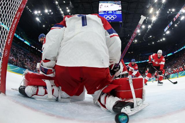Switzerland's #86 Janis Moser (R) assists Switzerland's #90 Roman Josi (not pictured) to score the team's first goal against Czech Republic's #01 Lukas Dostal during the men's preliminary round Group A Ice Hockey match between Switzerland and Czech Republic at the Milano Santagiulia Ice Hockey Arena during the Milano Cortina 2026 Winter Olympic Games in Milan, on February 15, 2026. (Photo by POOL / AFP)