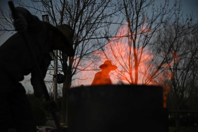 Men prepare for a molten iron fireworks performance in park in Beijing on February 15, 2026 ahead of the Lunar New Year of the Horse. (Photo by Pedro PARDO / AFP)