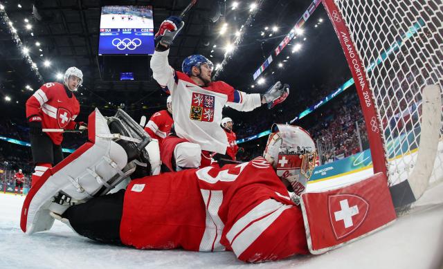 Czech Republic's #51 Radim Simek (back) celebrates scoring his team's second goal against Switzerland's #63 Leonardo Genoni during the men's preliminary round Group A Ice Hockey match between Switzerland and Czech Republic at the Milano Santagiulia Ice Hockey Arena during the Milano Cortina 2026 Winter Olympic Games in Milan, on February 15, 2026. (Photo by POOL / AFP)