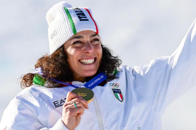 Gold medallist Italy's Federica Brignone (C) celebrates with team members after winning the women's giant slalom event during the Milano Cortina 2026 Winter Olympic Games at the Tofane Alpine Skiing Centre in Cortina d’Ampezzo on February 15, 2026. (Photo by Stefano RELLANDINI / AFP)