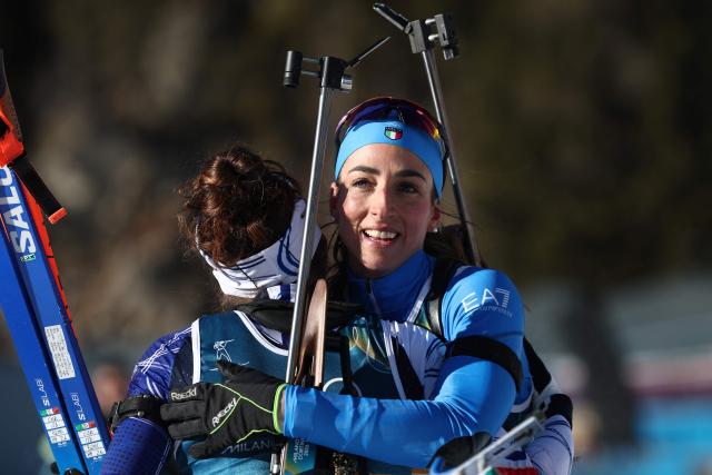 France's Lou Jeanmonnot (L) hugs Italy's Lisa Vittozzi (R) after they crossed the finish line during the women's biathlon 10km pursuit event during the Milano Cortina 2026 Winter Olympic Games at the Anterselva Biathlon Arena (Sudtirol Arena) in Anterselva (Val Pusteria) on February 15, 2026. (Photo by FRANCK FIFE / AFP)