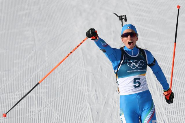 Italy's Lisa Vittozzi celebrates while crossing the finish line during the women's biathlon 10km pursuit event during the Milano Cortina 2026 Winter Olympic Games at the Anterselva Biathlon Arena (Sudtirol Arena) in Anterselva (Val Pusteria) on February 15, 2026. (Photo by Odd ANDERSEN / AFP)