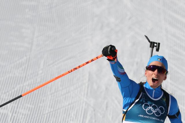 Italy's Lisa Vittozzi celebrates while crossing the finish line during the women's biathlon 10km pursuit event during the Milano Cortina 2026 Winter Olympic Games at the Anterselva Biathlon Arena (Sudtirol Arena) in Anterselva (Val Pusteria) on February 15, 2026. (Photo by Odd ANDERSEN / AFP)